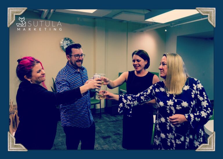 four people toasting glasses